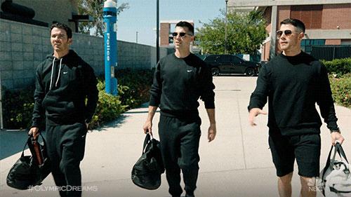 Allégorie de la globalisation esthétique du web par les Jonas Brothers. Les Jonas Brothers avec des survêtements noirs et sacs de sport