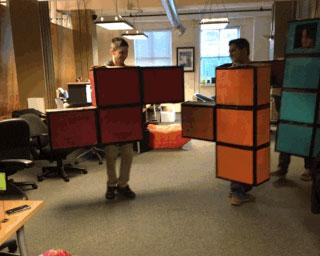 Trois designers UI collaborant en temps réel sur Figma via un design system. Trois personnes avec chacune un déguisement de briques de Tetris